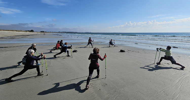Exercices sur la plage avec des bâtons de marche nordique